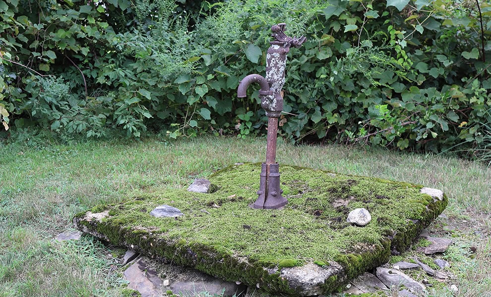 Historic pitcher pump and well in the yard of the Number 2 Schoolhouse, Charlton, Massachusetts by Peter Cooper Jr